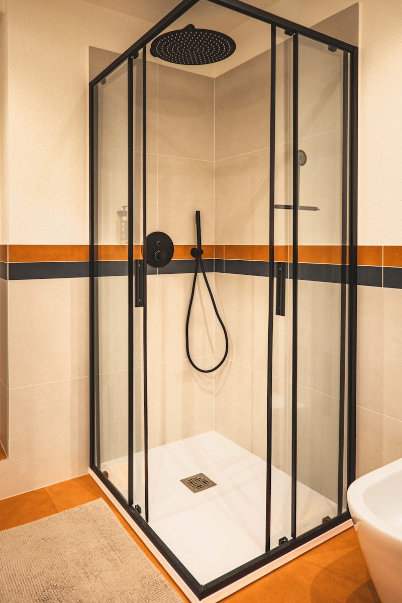 A modern shower enclosure with black accents.